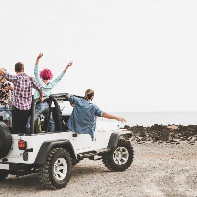 Group,Of,Friends,Driving,Off,Road,Convertible,Car,During,Roadtrip